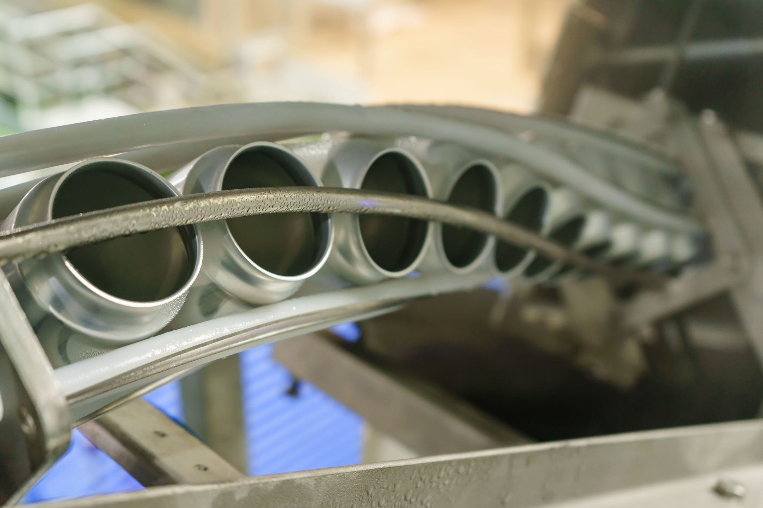 Upward conveyor line carrying aluminum beverage cans at craft brewery factory