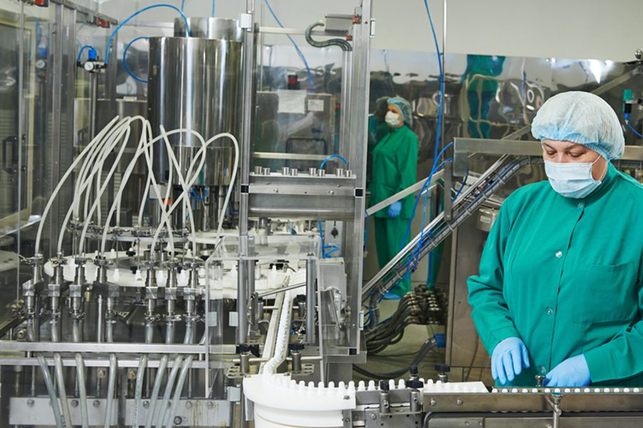 pharmaceutical production- workers operating machinery filling medicine bottles